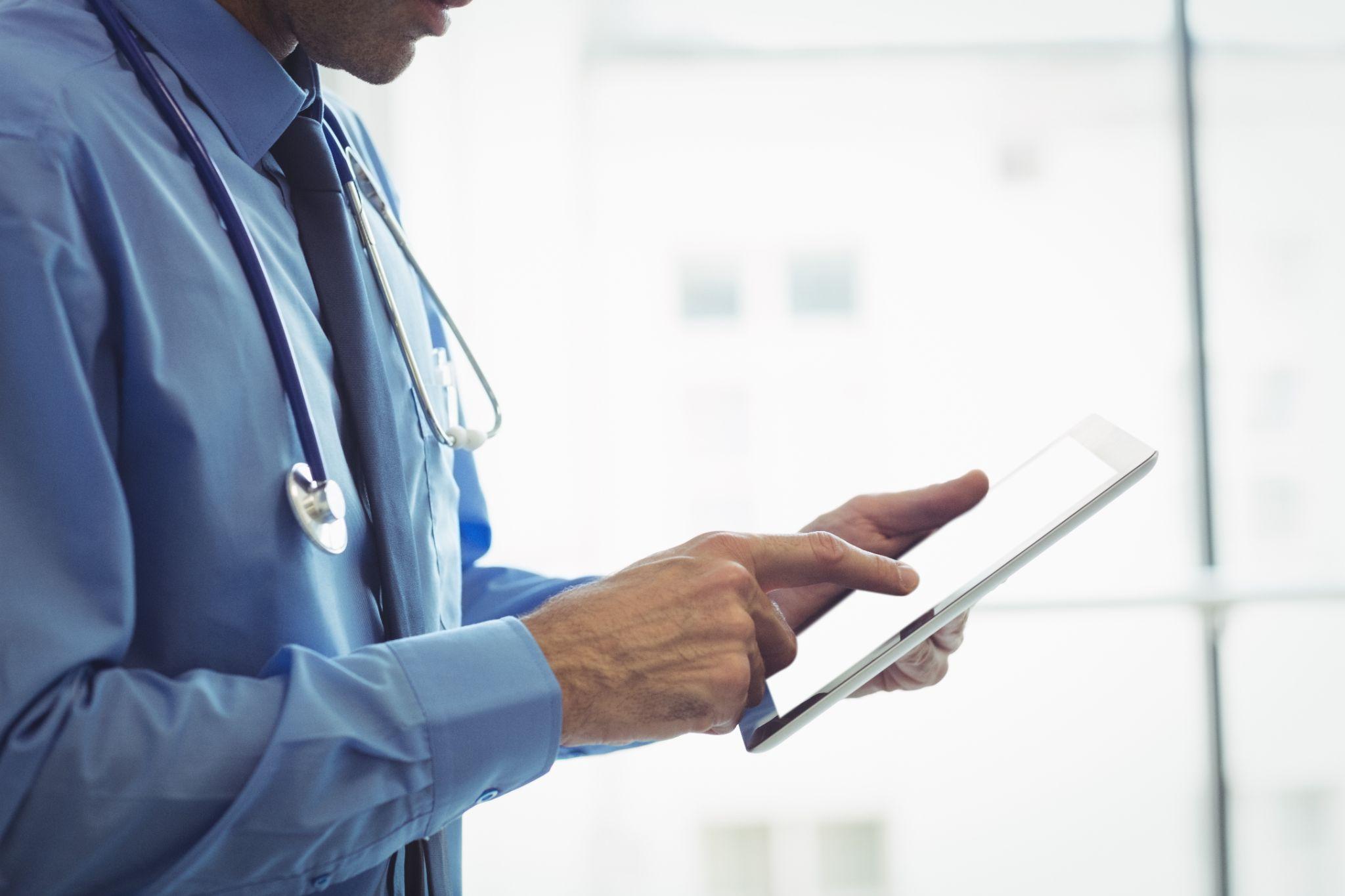 Clinician using an iPad to chart in ModMed or EZDerm